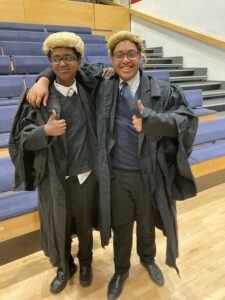 Two students wearing judicial gowns and wigs