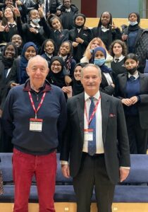 Judge Horton and a staff member of Bristol Academy posing for a photo with students sat behind them