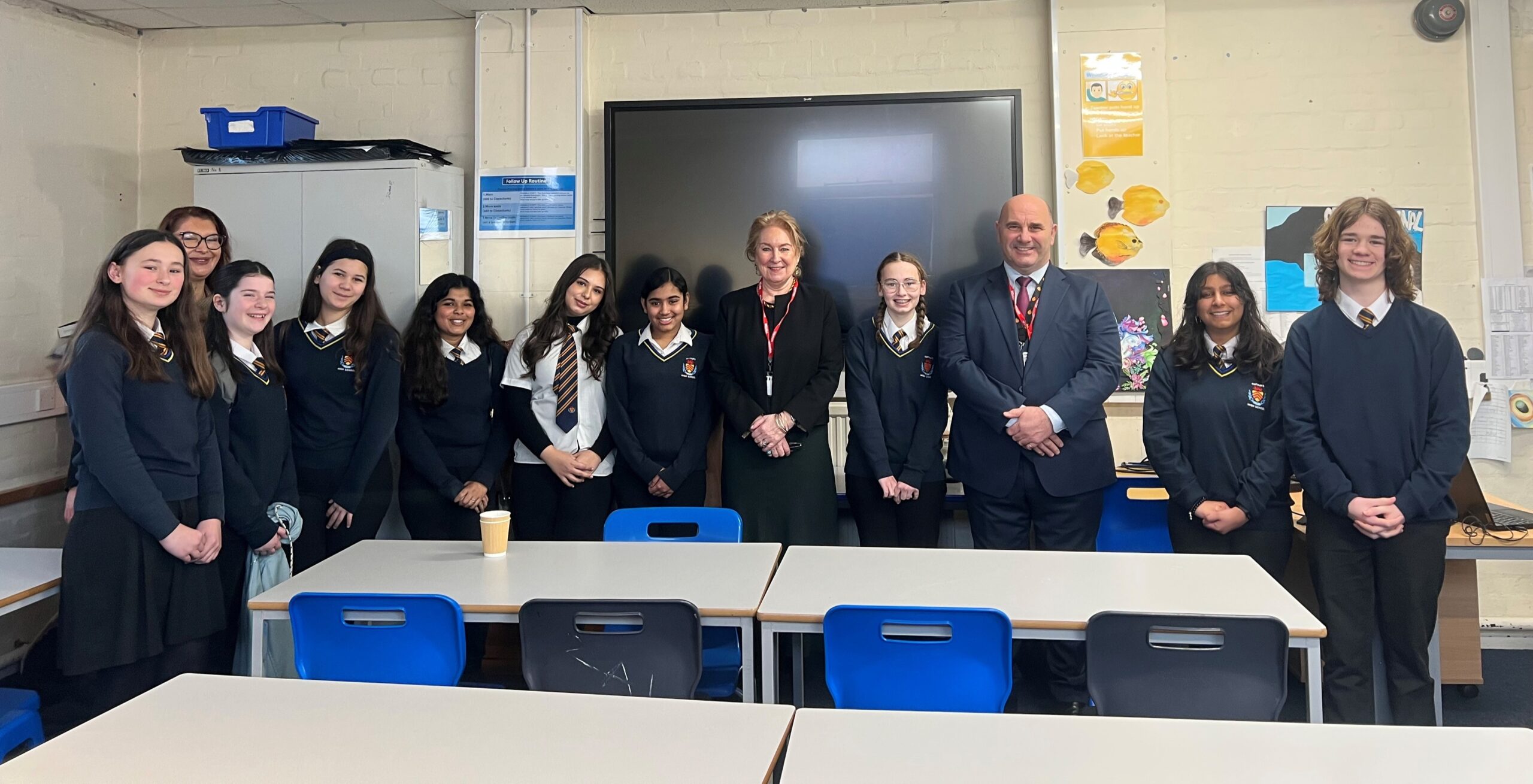 Lady Chief Justice in a school classroom, with school pupils standing either side of her